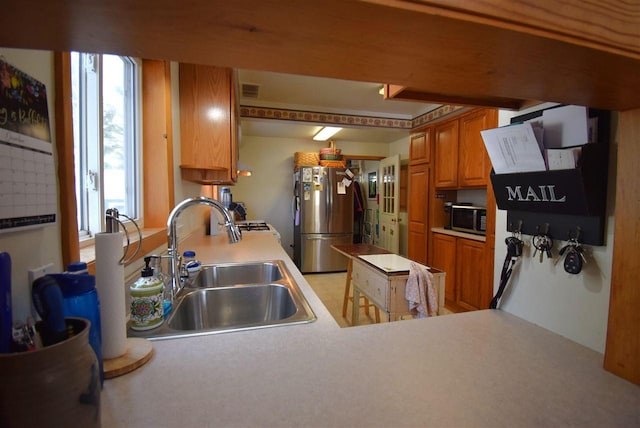 kitchen featuring kitchen peninsula, appliances with stainless steel finishes, and sink