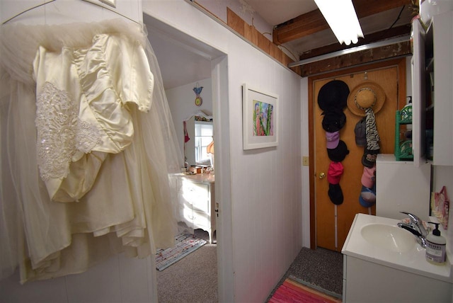 bathroom featuring vanity and wooden walls