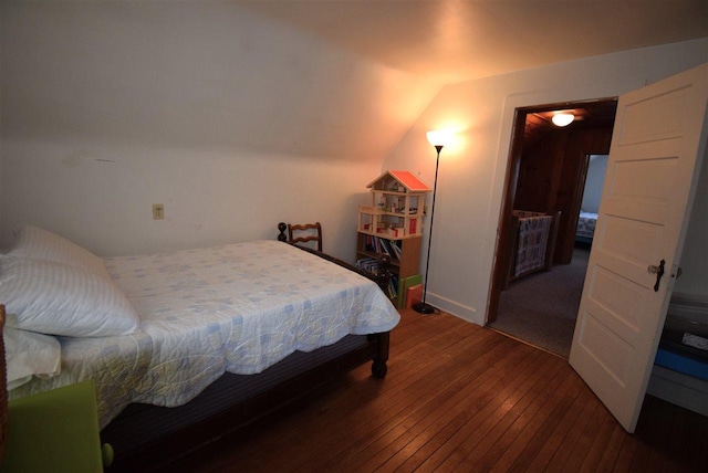 bedroom with hardwood / wood-style flooring and lofted ceiling