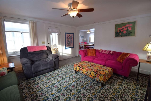 carpeted living room with ceiling fan and crown molding