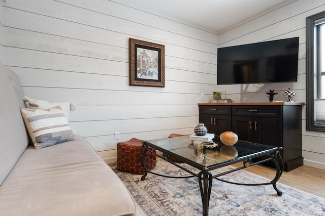 living room featuring light hardwood / wood-style floors and wooden walls