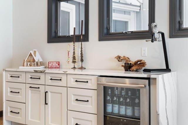 bar featuring white cabinets and beverage cooler