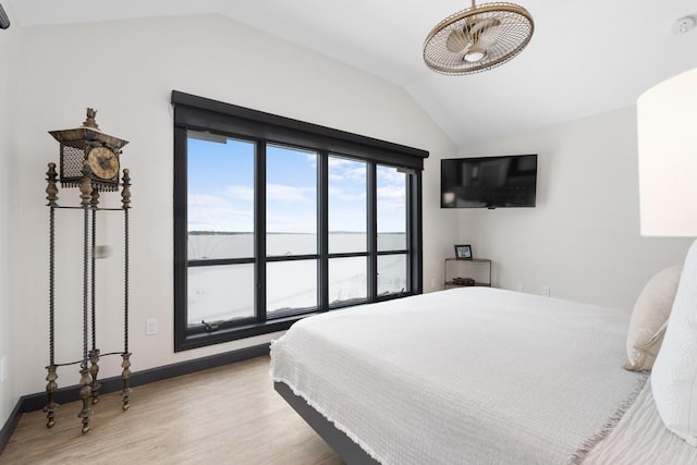 bedroom with light hardwood / wood-style flooring and lofted ceiling