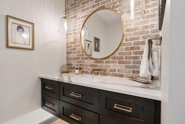 bathroom with vanity and brick wall