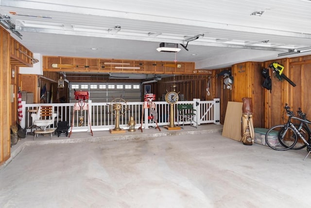 garage featuring a garage door opener and wooden walls