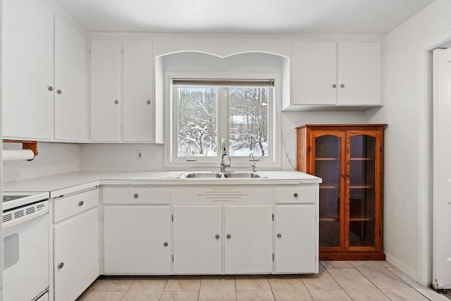 kitchen featuring sink, white cabinets, white stove, and light tile patterned floors