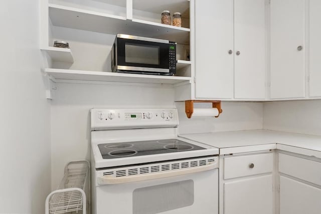 kitchen with white electric range and white cabinetry