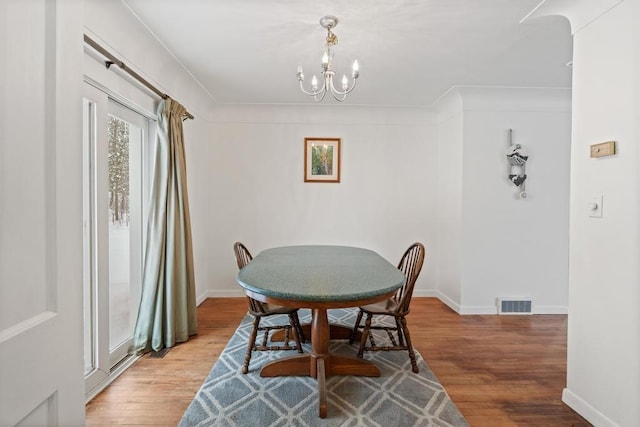 dining room featuring wood-type flooring and a chandelier