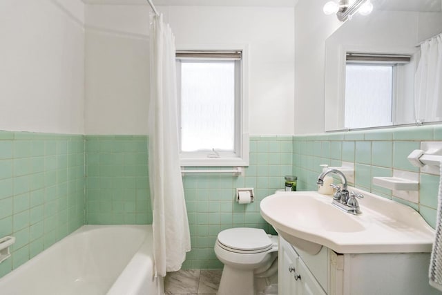 full bathroom with vanity, a healthy amount of sunlight, toilet, and tile walls