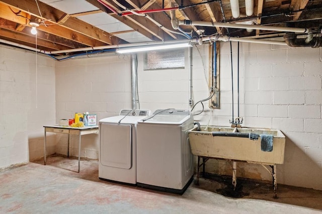 clothes washing area with independent washer and dryer and sink