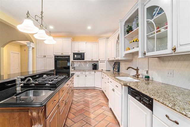 kitchen with light stone countertops, hanging light fixtures, decorative backsplash, white cabinets, and black appliances