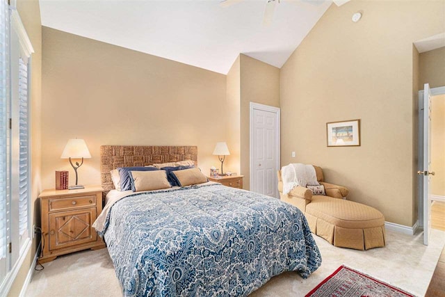 bedroom featuring ceiling fan, high vaulted ceiling, and light carpet