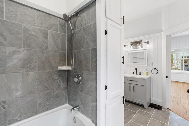 bathroom with tile patterned flooring, tiled shower / bath combo, and vanity