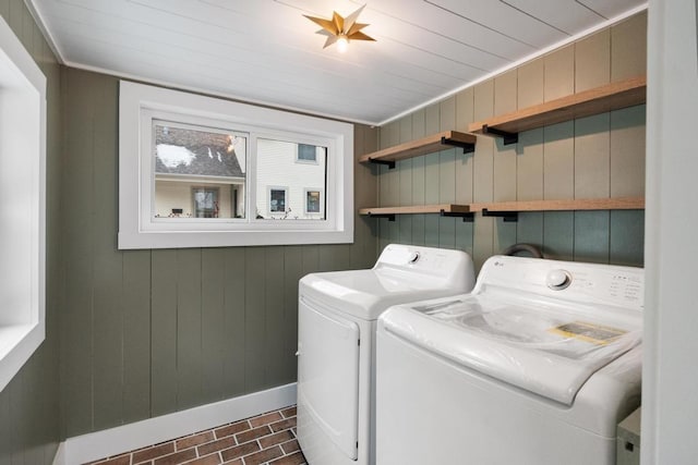 laundry room featuring wood ceiling, independent washer and dryer, and wooden walls