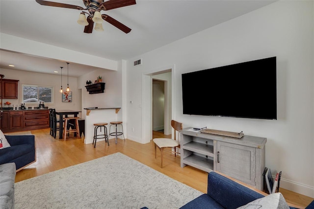 living room featuring light wood-type flooring and ceiling fan