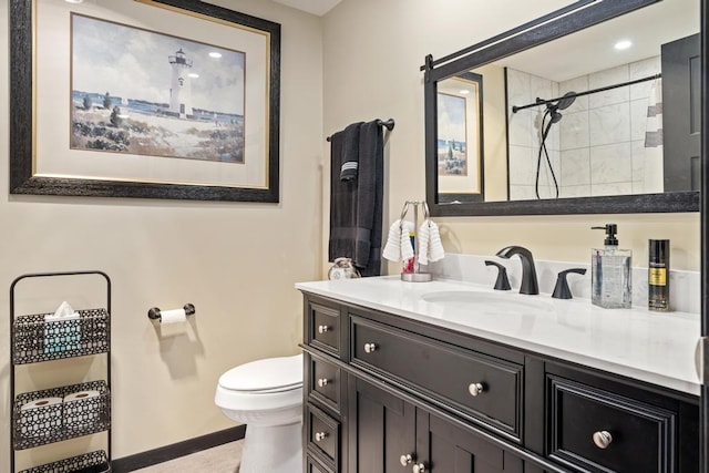 bathroom featuring vanity, toilet, and tiled shower