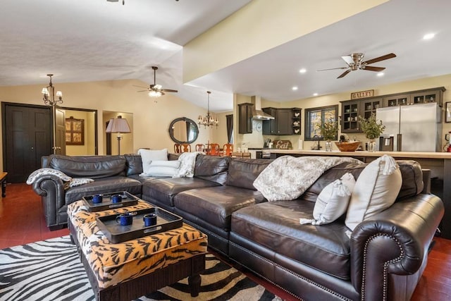 living room with ceiling fan with notable chandelier, lofted ceiling, and dark wood-type flooring