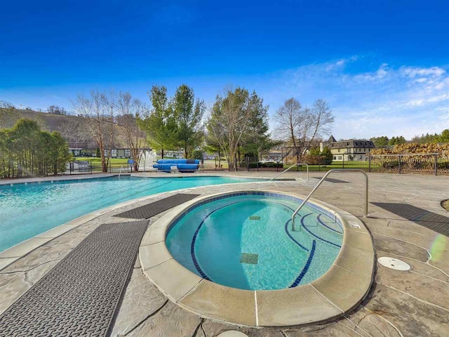 view of swimming pool featuring an in ground hot tub