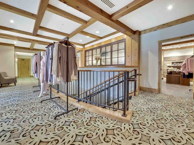 hall with beam ceiling, light colored carpet, and coffered ceiling