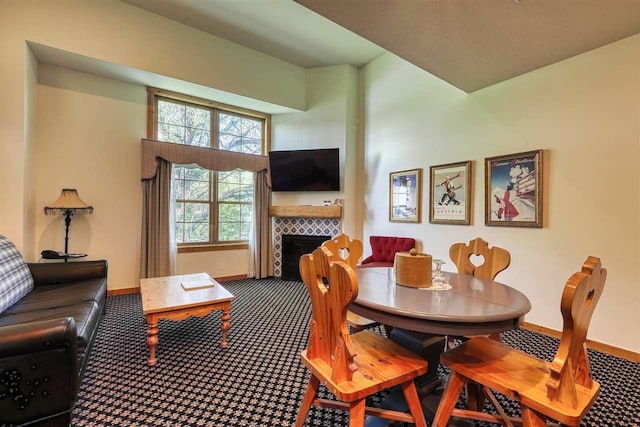 carpeted dining space featuring a tiled fireplace