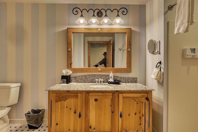 bathroom with tile patterned flooring, vanity, and toilet