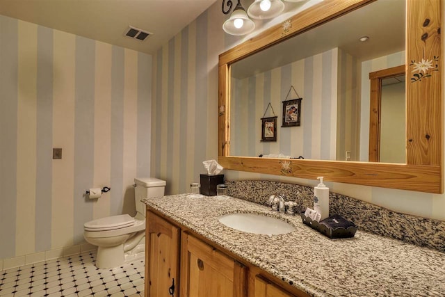 bathroom with tile patterned flooring, vanity, and toilet