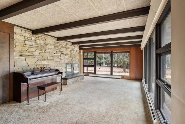 misc room with beamed ceiling, a baseboard heating unit, carpet floors, and wooden walls