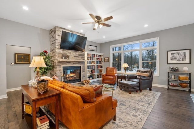 living room featuring dark hardwood / wood-style floors, ceiling fan, and a tile fireplace