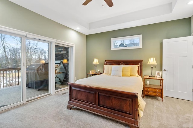 bedroom with a raised ceiling, access to exterior, ceiling fan, and light colored carpet