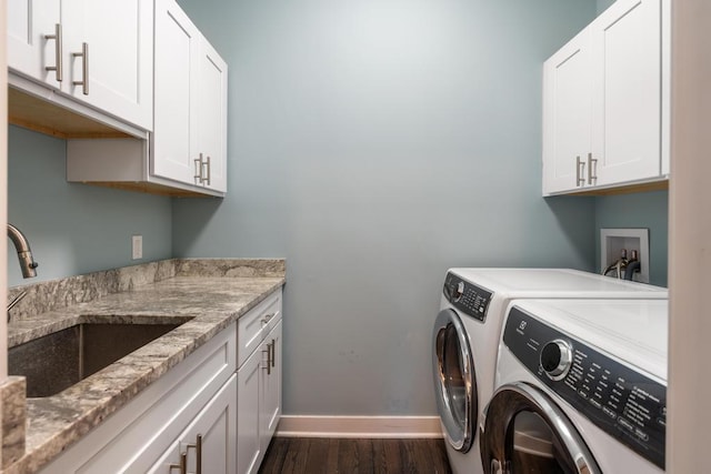 washroom featuring cabinets, dark hardwood / wood-style flooring, washing machine and dryer, and sink