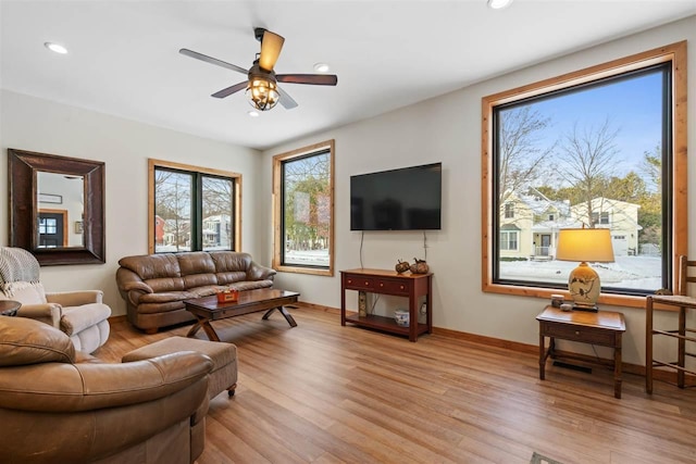 living room with light hardwood / wood-style flooring and ceiling fan