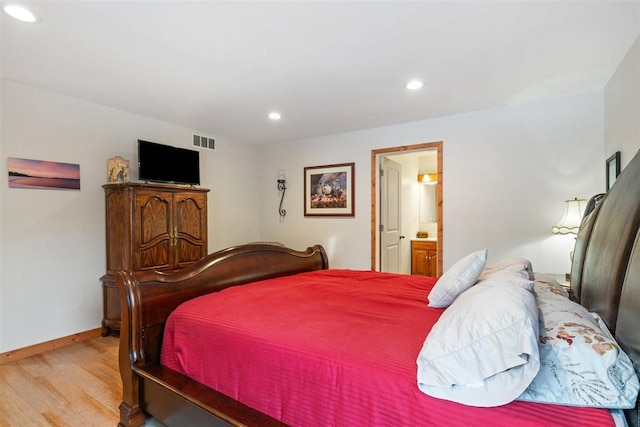 bedroom featuring ensuite bath and light hardwood / wood-style floors