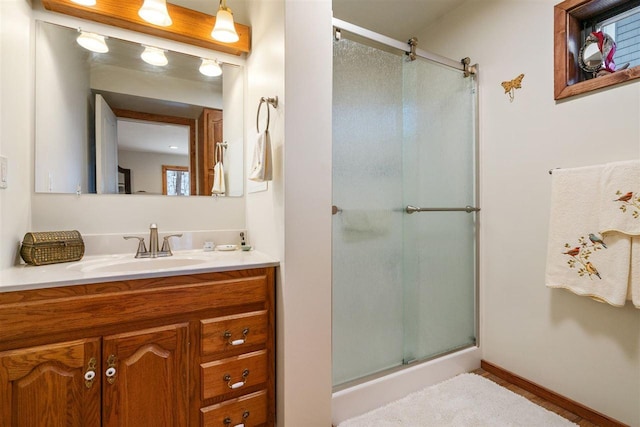 bathroom with vanity and a shower with door