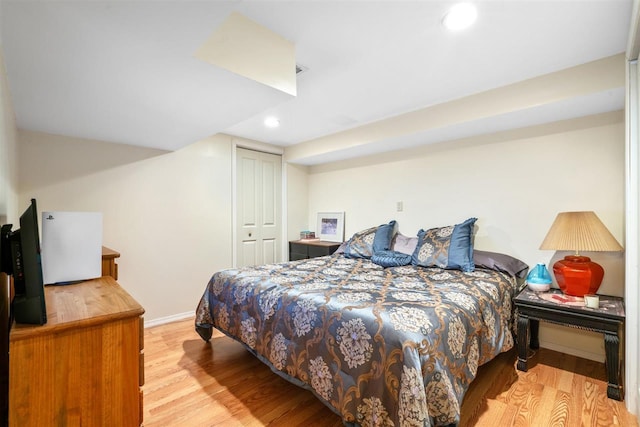 bedroom with light hardwood / wood-style flooring and a closet