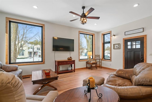 living room featuring ceiling fan and light hardwood / wood-style floors