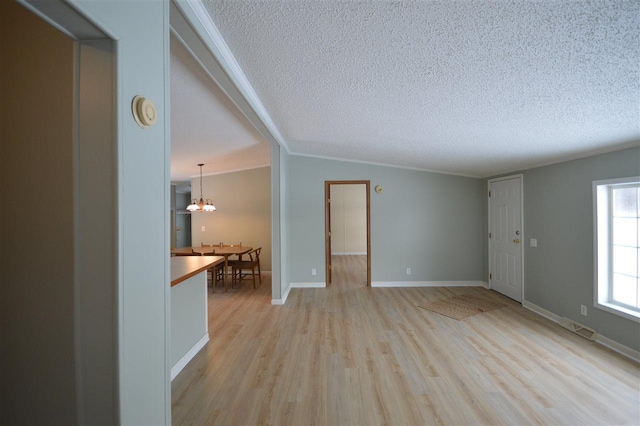 unfurnished living room with light wood-type flooring, a textured ceiling, and a chandelier