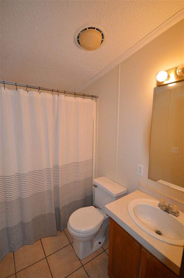 bathroom featuring tile patterned floors, ornamental molding, vanity, a textured ceiling, and toilet