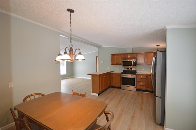 kitchen featuring kitchen peninsula, appliances with stainless steel finishes, crown molding, light hardwood / wood-style floors, and hanging light fixtures