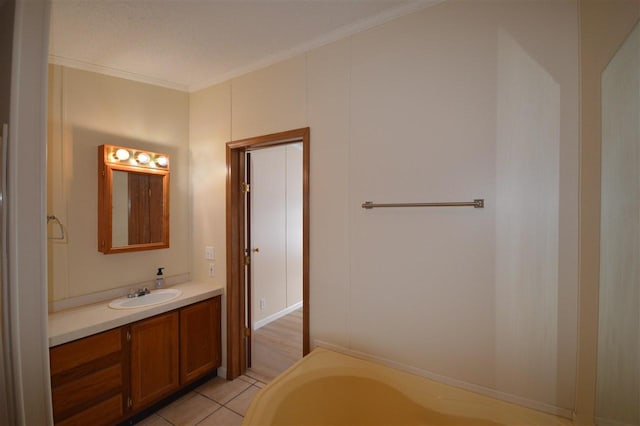 bathroom with tile patterned flooring, vanity, a bathtub, and crown molding