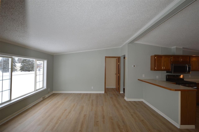 unfurnished living room featuring a textured ceiling, light hardwood / wood-style floors, and ornamental molding