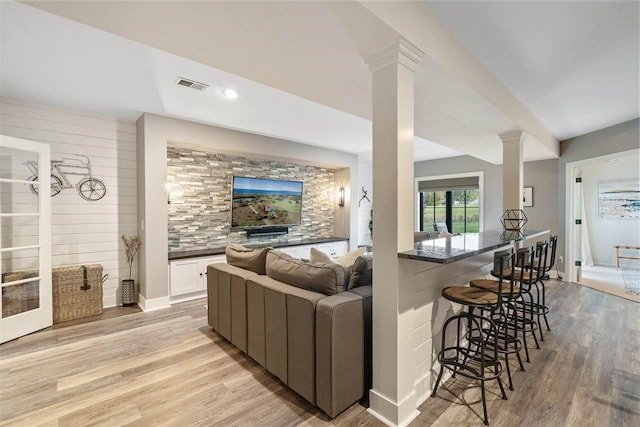 living room with light hardwood / wood-style floors and decorative columns