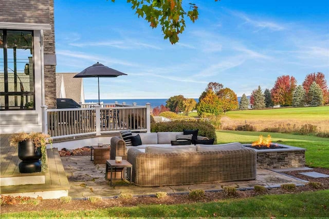 view of patio / terrace with a water view and an outdoor living space with a fire pit