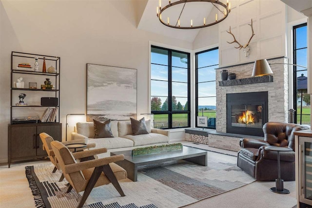 interior space featuring a chandelier, light colored carpet, high vaulted ceiling, and a fireplace