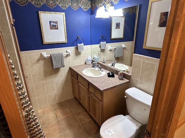 bathroom featuring tile patterned flooring, vanity, toilet, and tile walls