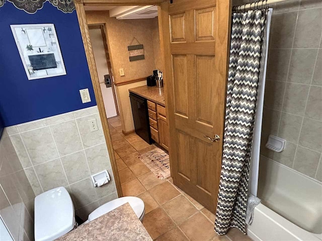 bathroom featuring tile patterned flooring, shower / bathtub combination with curtain, tile walls, and toilet