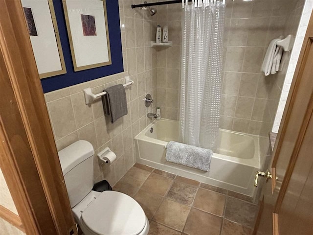 bathroom featuring toilet, shower / bathtub combination with curtain, and tile walls