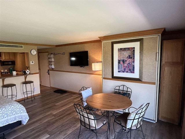 dining room with dark hardwood / wood-style floors and crown molding