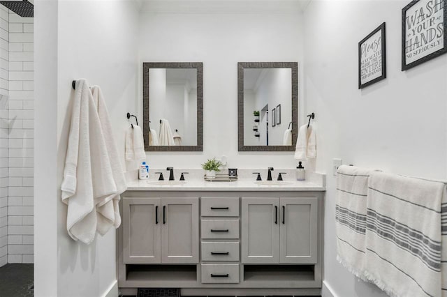 bathroom with vanity, a tile shower, and ornamental molding