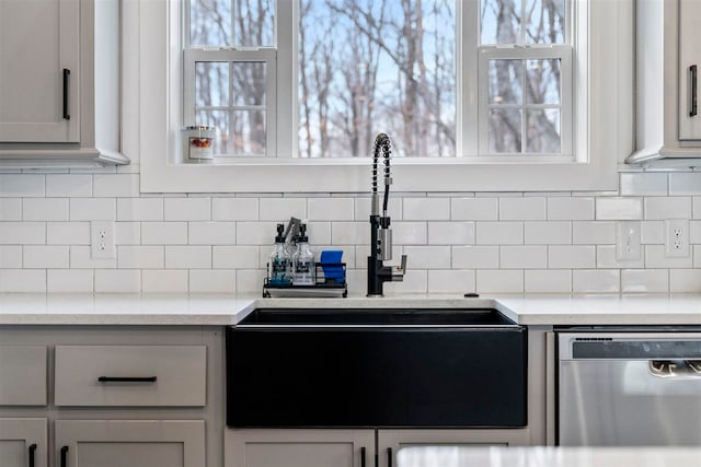 kitchen featuring backsplash, dishwasher, and sink