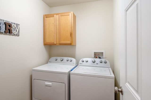 washroom with cabinets and washing machine and clothes dryer